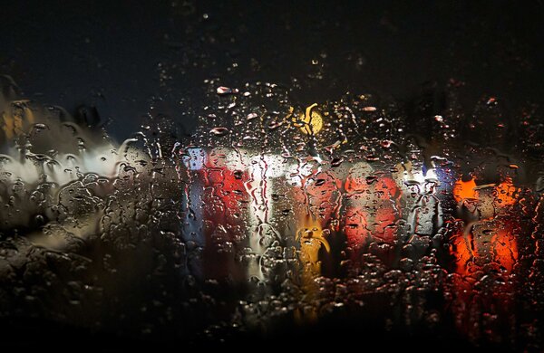 gotas_de_agua_na_janela_borrando_as_luzes_do_lado_de_fora_com_um_preto